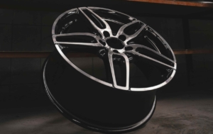 A car wheel leaning up against a wall, ready to be picked up by a freight company that specializes in automotive parts shipping